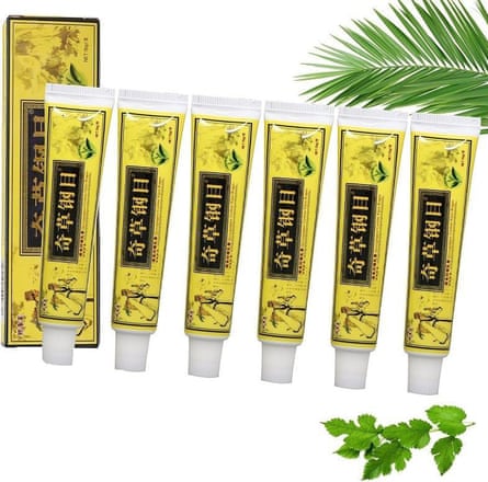 Six yellow and black tubes of Meitrend Natural Face Cream and one box, a green palm leaf comes into the frame from the top right corner while green herbs are pictured below
