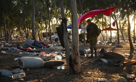 Israeli soldiers search for ID and belongings among the tents at the Nova music festival site on 12 October.