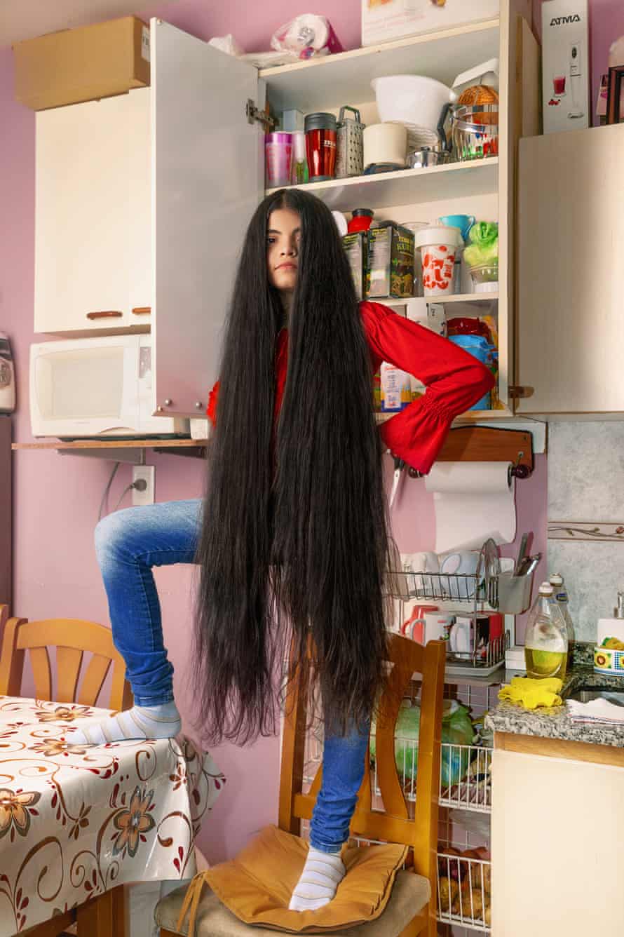 Antonella Bordon standing on a chair in her kitchen, with her long hair down to her knees