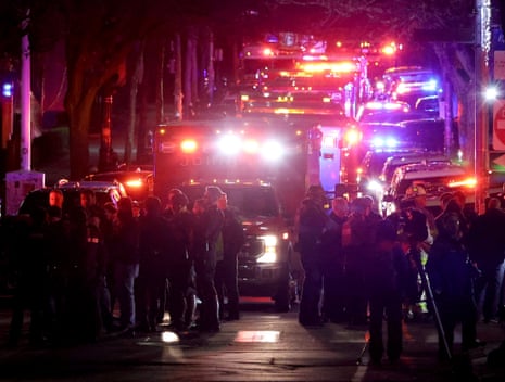 Emergency personnel gather on a street at night