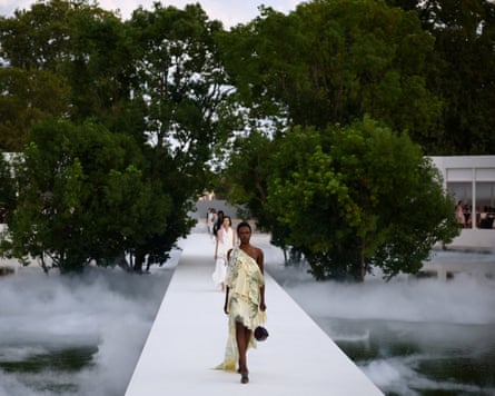 Model wearing a layered dress with long train.
