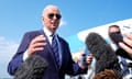 Man in sunglasses wearing suit speaks to reporters
