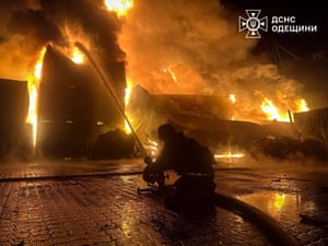 A firefighter sprays water on to a burning building
