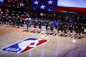 Players from Orlando Magic and Milwaukee Bucks take a knee during the national anthem before the start of Game 3 of an NBA basketball first-round playoff series, Saturday, Aug. 22, 2020, in Lake Buena Vista, Fla. (Mike Ehrmann/Pool Photo via AP)