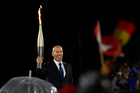 पूर्व फ्रेन्च फुटबल खेलाडी र व्यवस्थापक जिनेदिन जिदानले ज्वाला बोकेका छन् । फोटोग्राफः लोइक वेनांसर गेटी इमेज