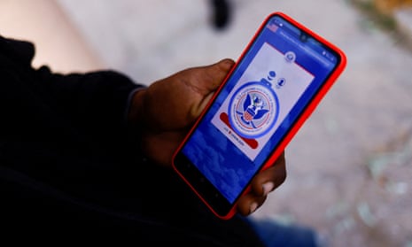 A migrant from Venezuela seeking asylum in the US uses his phone to access the CBP One application.