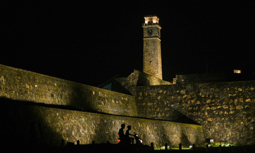 People ride a scooter past Galle fort in Galle, Sri Lanka.