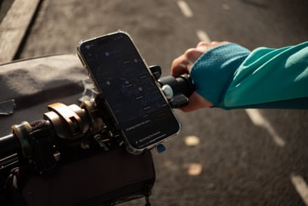 A Deliveroo driver with his hands on bicycle brakes