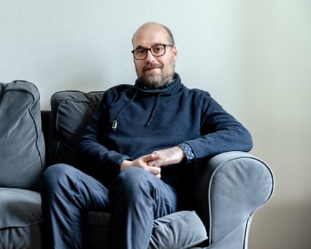 Péter Erdélyi sits on a sofa.