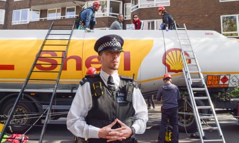 Etienne Stott (seated, left) and another XR activist on top of the oil tanker in Bayswater, London.