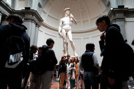 Tourists take photos in front of Michelangelo’s David in the Accademia Gallery in Florence