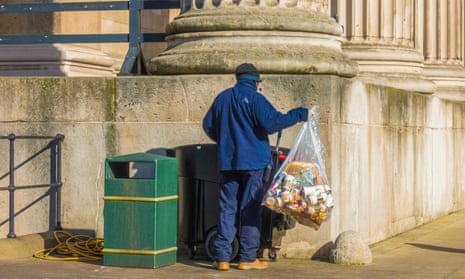 Man empties bag into wheelie bin