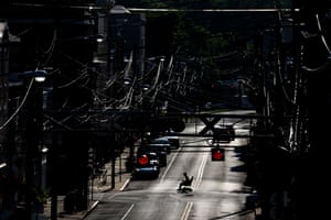 A man in an electric wheelchair crosses Pike Street in the sweltering heat in Kentucky