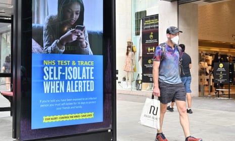 Regent Street in London with shopper wearing mask walking past poster advising people to self-isolate if contacted