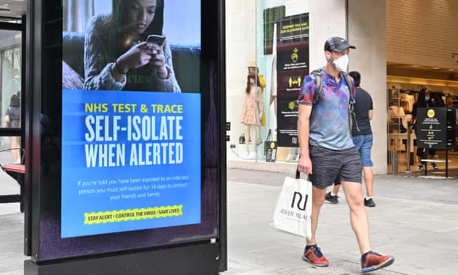 A shopper walks past an advertisement for the NHS test and trace system.