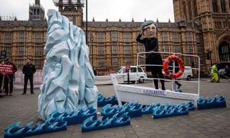 A model of Theresa May on HMS Brexit sails towards an iceberg outside parliament.