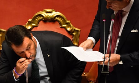 Salvini kisses a rosary as Conte delivers his speech to the Italian Senate.