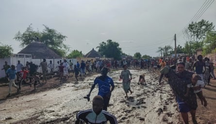 People running through a muddy street.