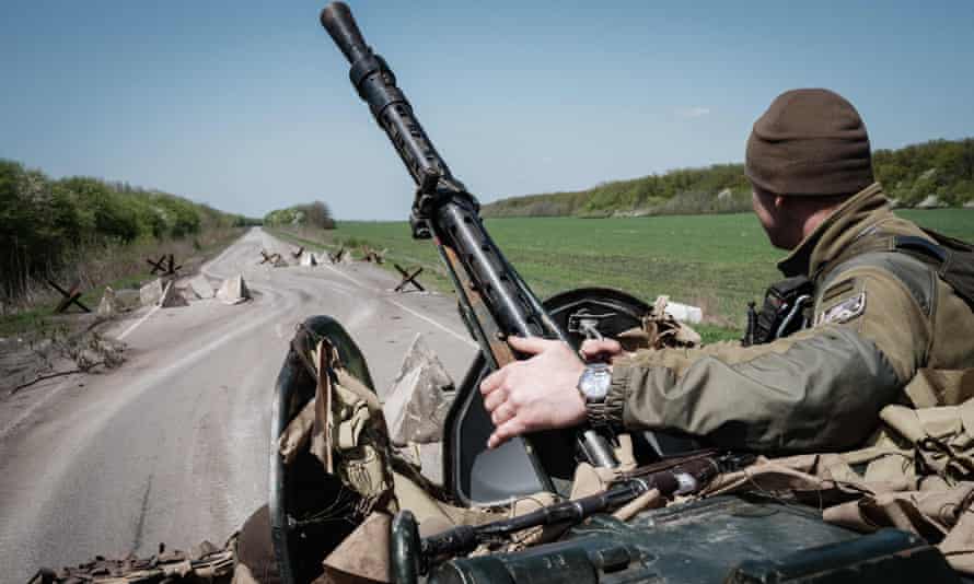 A Ukrainian soldier sits on an armoured personnel carrier driving on a road near Slovyansk, eastern Ukraine