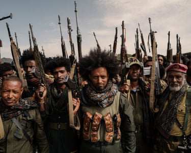 Men with rifles pointing into the air pose for the camera