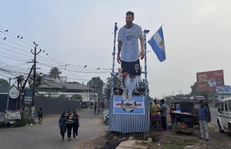 People walk past a cutout photo of Lionel Messi in Kochi, Kerala state