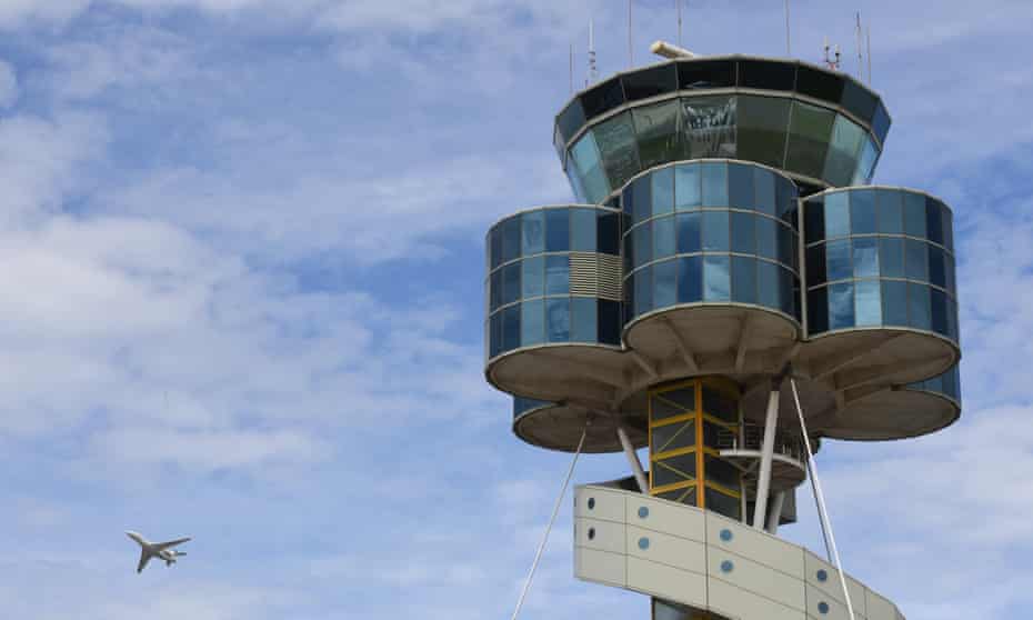 The control tower at Sydney Airport is seen as a plane takes off 