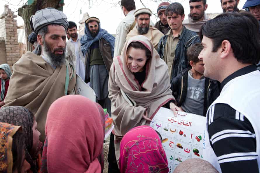 UNHCR Goodwill Ambassador Angelina Jolie presents education materials to local Headteacher, Gul Rahman, and young schoolgirls in the village of Qala Gudar, Qarabagh District February 2011 some 28km outside Kabul, Afghanistan.
