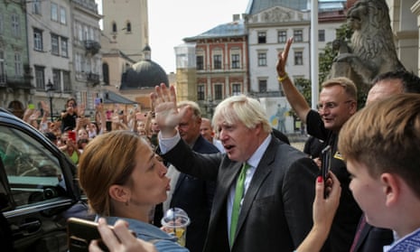 Boris Johnson and the mayor of Lviv wave to onlookers in a square of the city
