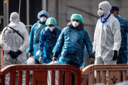 Passengers carry their belongings in plastic bags after being evacuated from the MV Hondius.