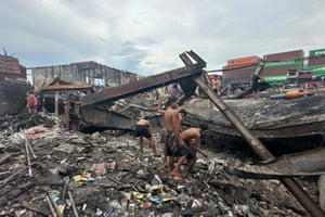 Men look for items in the remains of a fire-damaged building