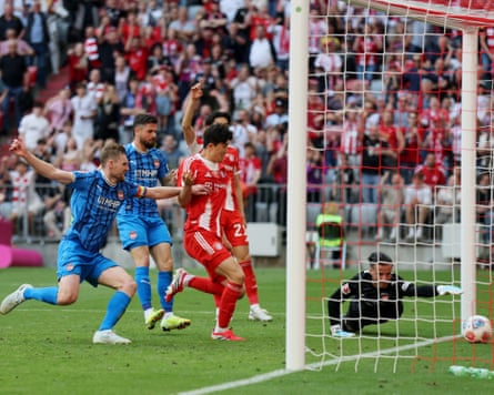 Diant Ramaj, the Heidenheim goalkeeper, dives in vain to stop the ball going over the line for Bayern Munich’s third goal in a 3-3 draw between the two teams in their Bundesliga game at the Allianz Arena.