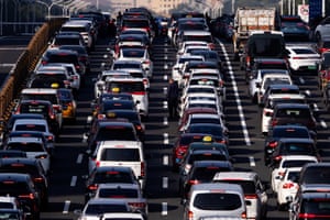 A man stands by his car amid a traffic jam on a motorway