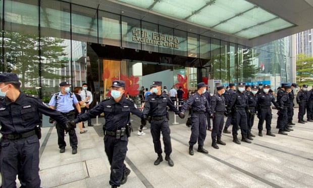 Security personnel form a human chain as they guard outside the Evergrande's headquarters, where people gathered to demand repayment of loans and financial products, in Shenzhen on Monday.