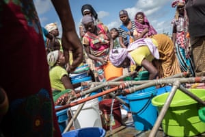 Women surround one of 16 water outlets for 30,000 displaced people at 25 de Junho camp
