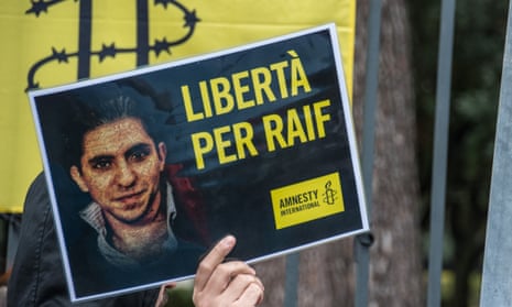 Sign depicting Raif Badawi held by Amnesty International activists