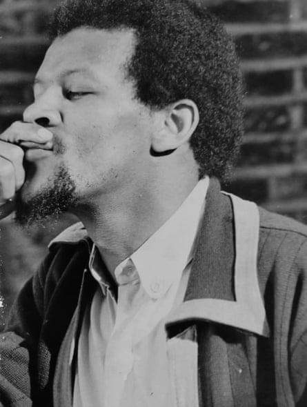 a black and white photo shows him holding his hand to his mouth