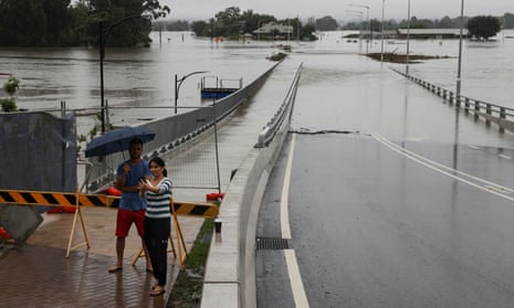 A woman takes a selfie in front of a flooded bridge in the suburb of Windsor as the state of New South Wales experiences widespread flooding and severe weather, in Sydney, Australia, March 22, 2021.