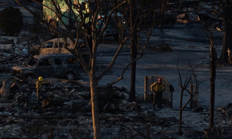 Firefighters walk around the remains of homes destroyed by the Palisades Fire in the Pacific Palisades neighborhood in Los Angeles, California, U.S. January 11, 2025. REUTERS/Carlos Barria