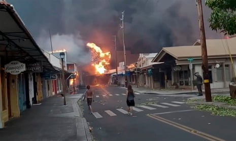 People watch as smoke and flames fill the air from raging wildfires on Front Street in downtown Lahaina, Maui on Tuesday, 9 August 2023.