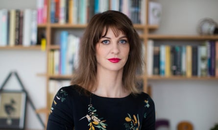 Gemma Carey stands in front of a bookshelf facing the camera
