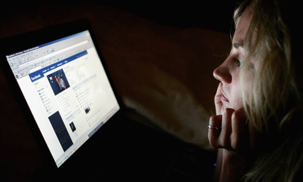 A woman reads a Facebook page