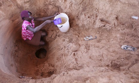 A woman fetches drinking water from a well in Zimbabwe