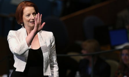 Julia Gillard in a public forum, smiling and with her hand raised