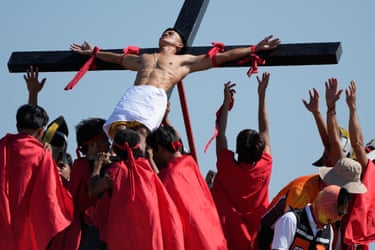Image 12: The actor on the cross is lowered down by a group in red robes