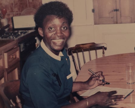 Williams smiles at the camera while sitting at a table writing notes
