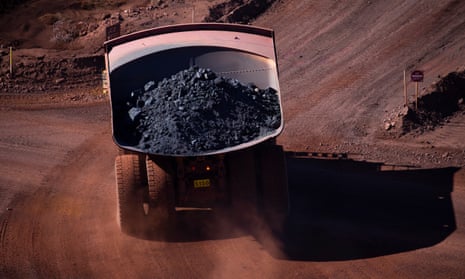 A loaded iron ore truck drives through the site at BHP Mt Whaleback Mine in Newman, Western Australia