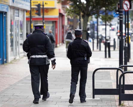 Two police officers walking away from the camera
