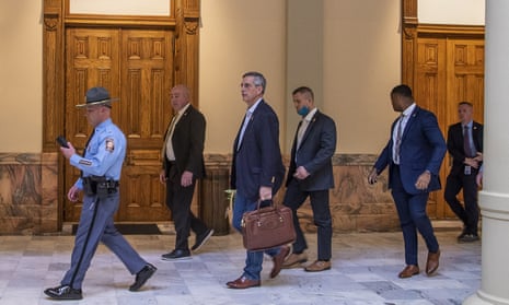 Brad Raffensperger, the Georgia secretary of state, center, leaves the state capitol building after reports of threats on 6 January.