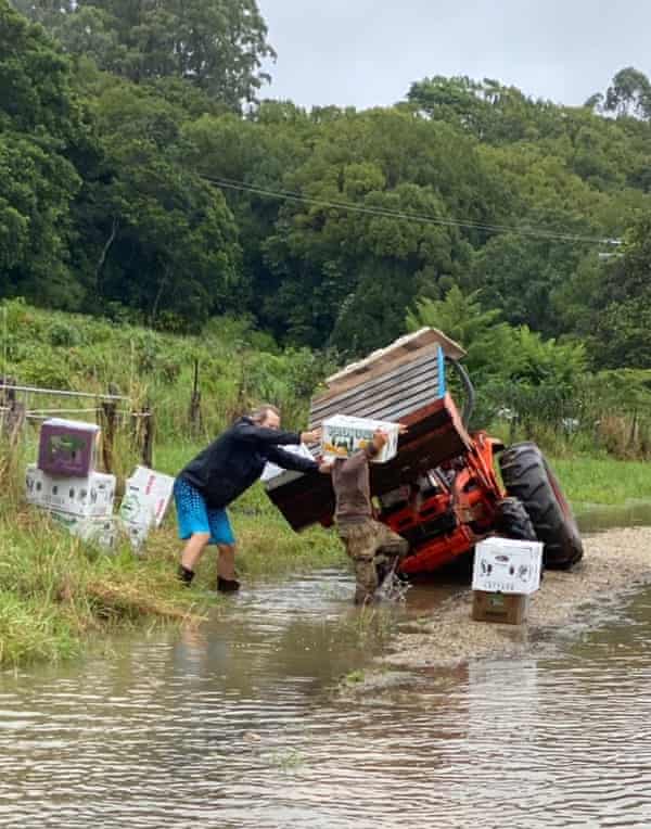 Boxes are loaded on to a tractor beside flooded ground on the farm