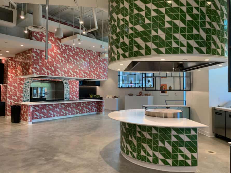 A large space has two brightly tiled stations. At the right is a semi-circular counter with a large comal, or circular griddle, in the center.